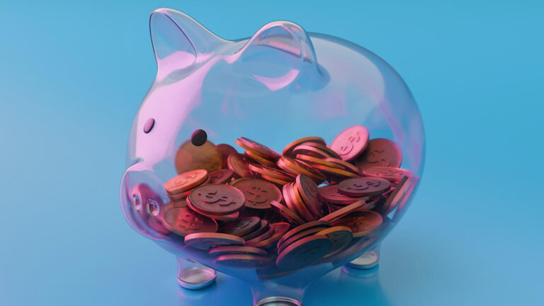 Clear piggy bank with fake coins inside.