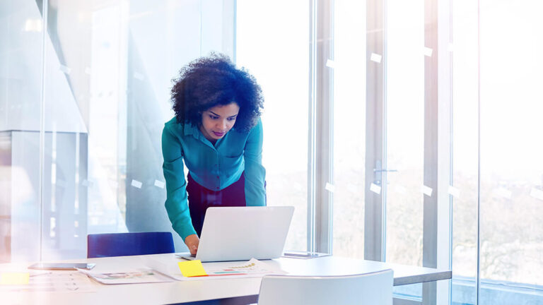 Woman conducting a pay audit on laptop.