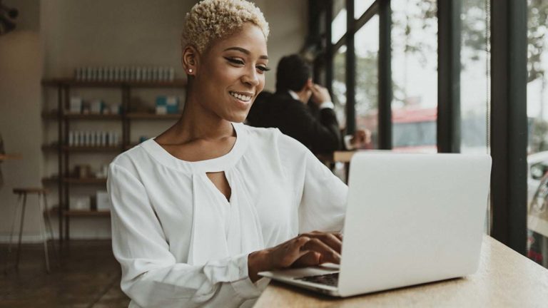 Smiling woman using a laptop.