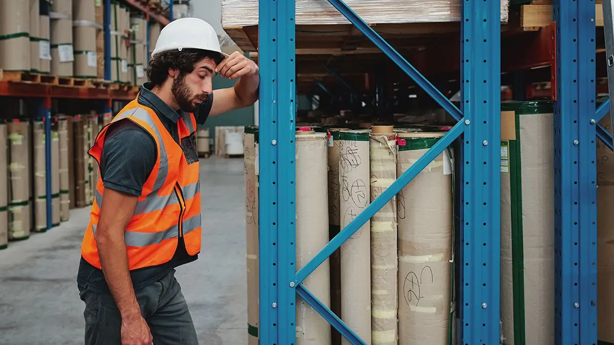 worker suffering from headache and rubbing his head