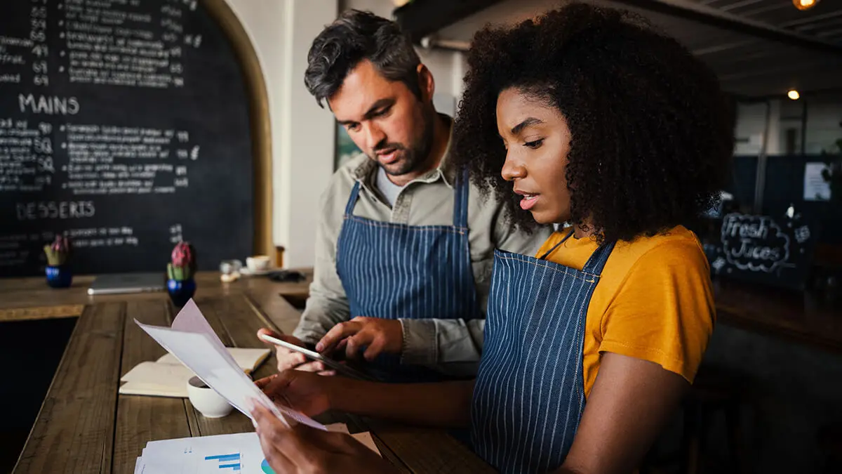 Business owner and employee reviewing paperwork