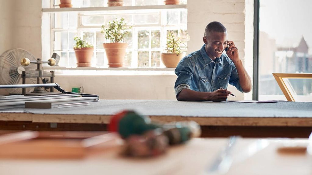 Entrepreneur on the phone learning how to get a business credit card.