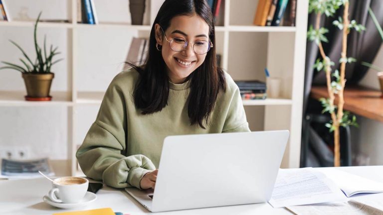 Smiling woman on a laptop.