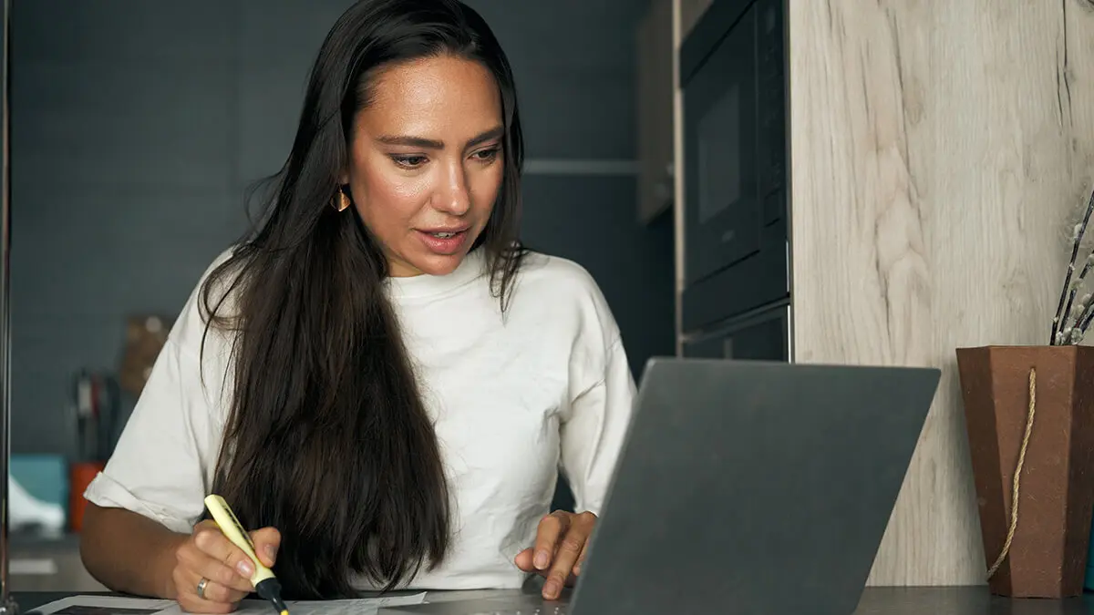 Woman using laptop to research additional Medicare tax