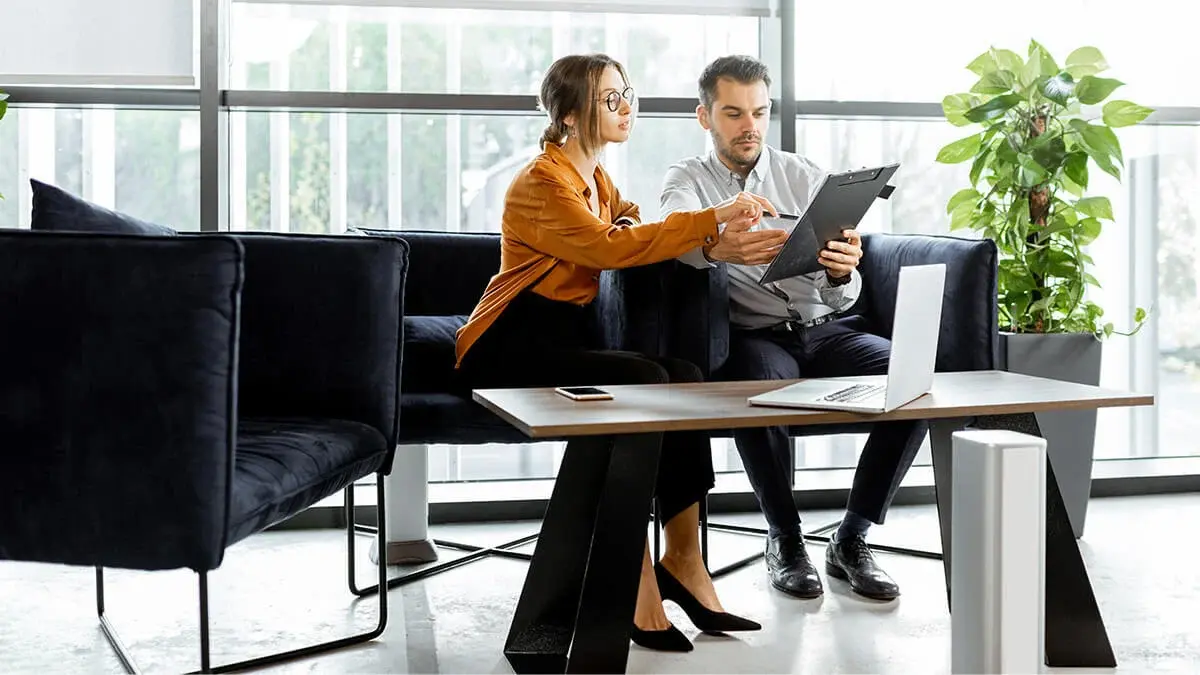 Two co-workers looking at a tablet.