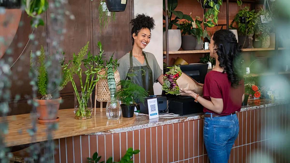 Woman buying a bouquet of flowers at a flower shop.