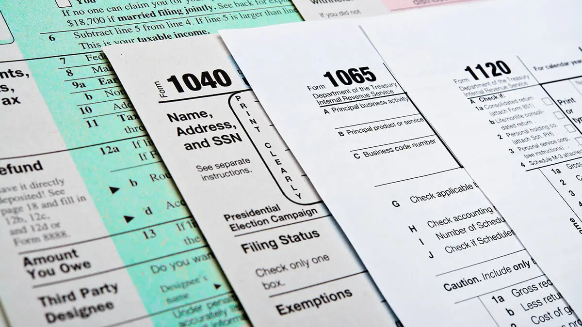 Stack of forms including Form 1040, 1065, and 1120.