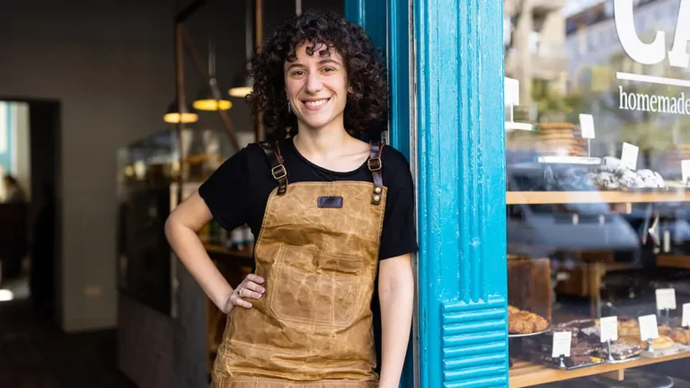 Business owner poses in front of storefront