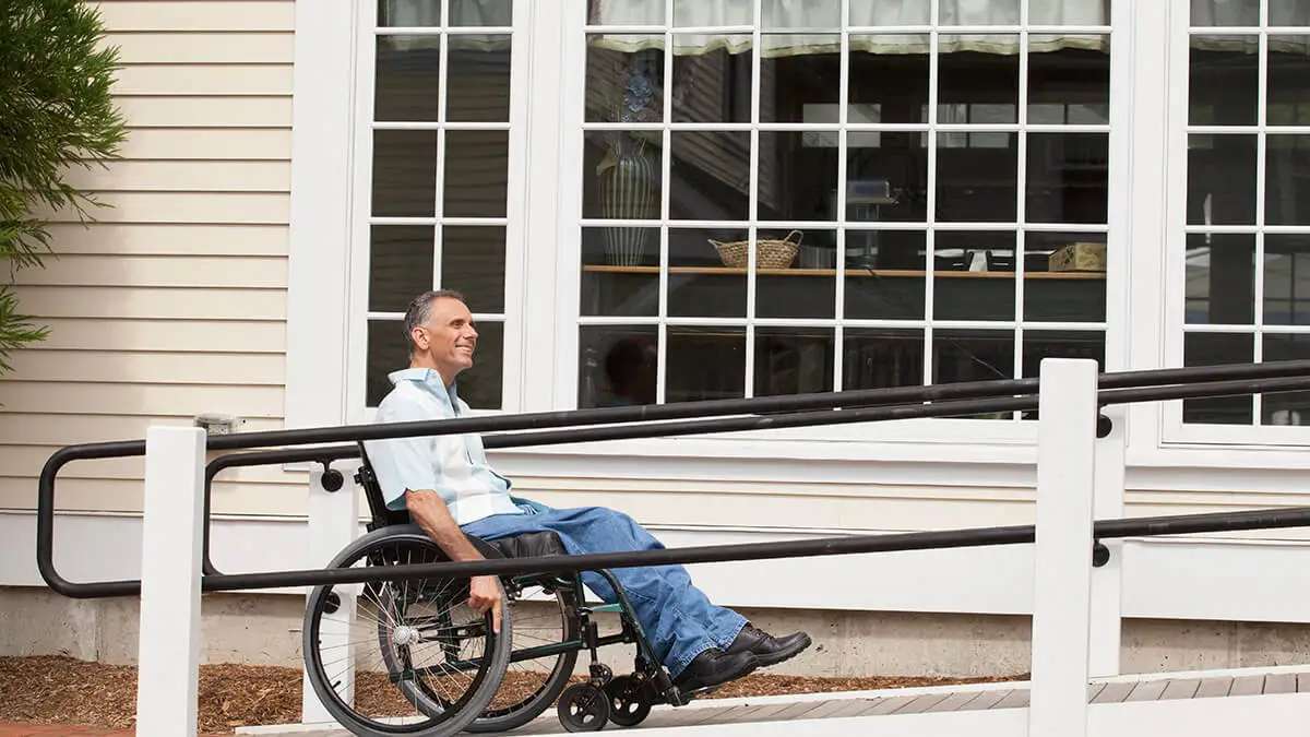 Man in wheelchair going up a ramp