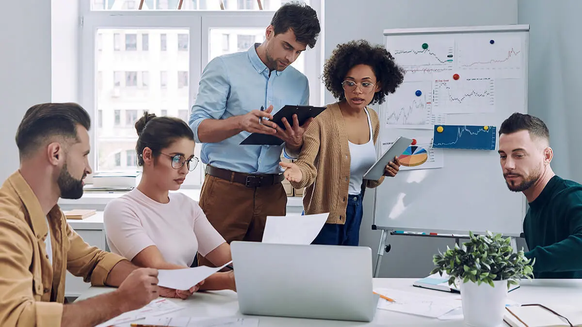 Employees reviewing statistics in a team meeting