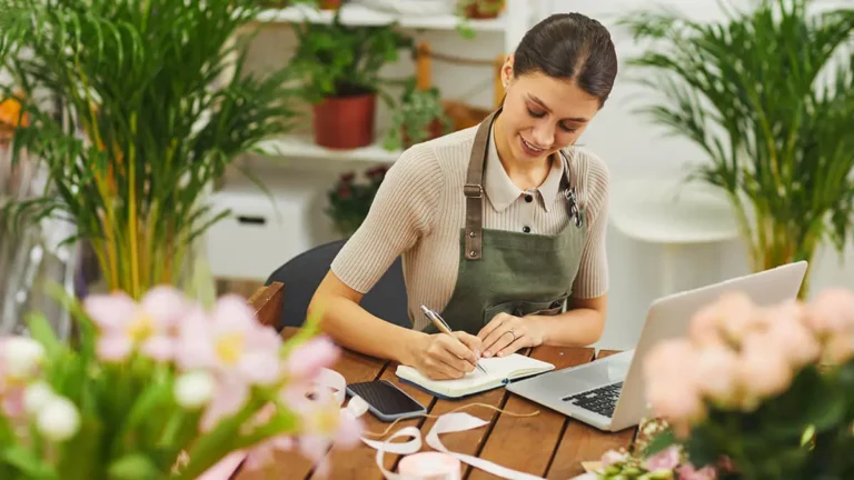 Woman in a flower shop writing on notepad