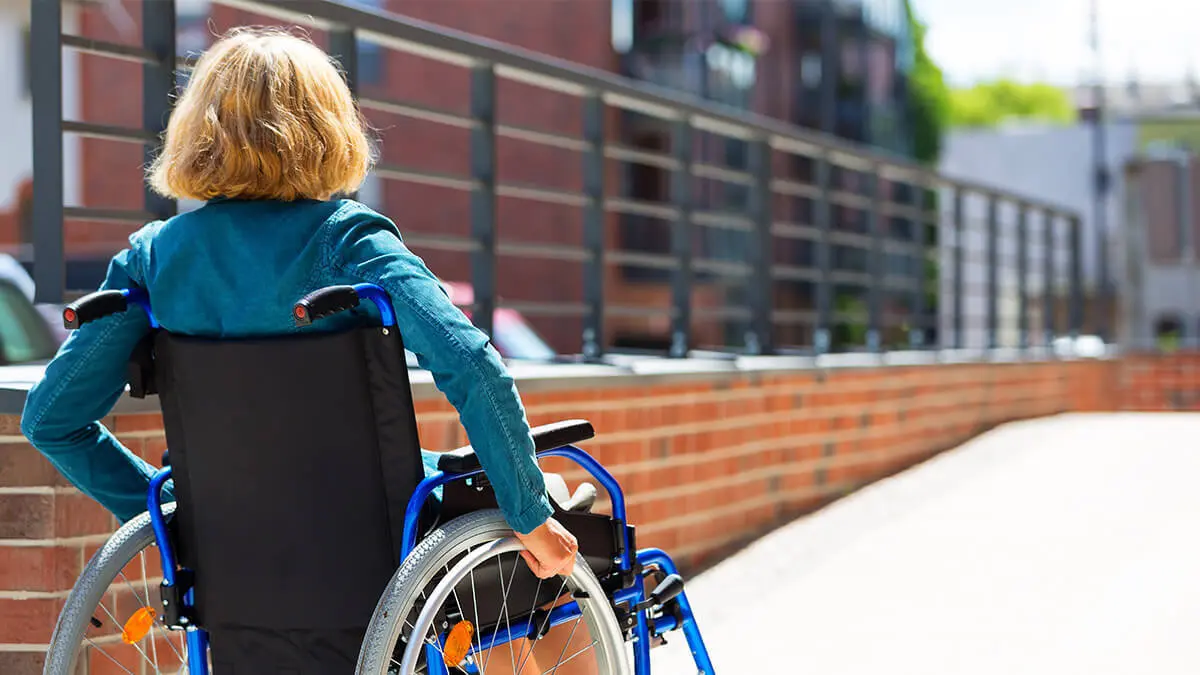 Woman in a wheelchair going up a ramp