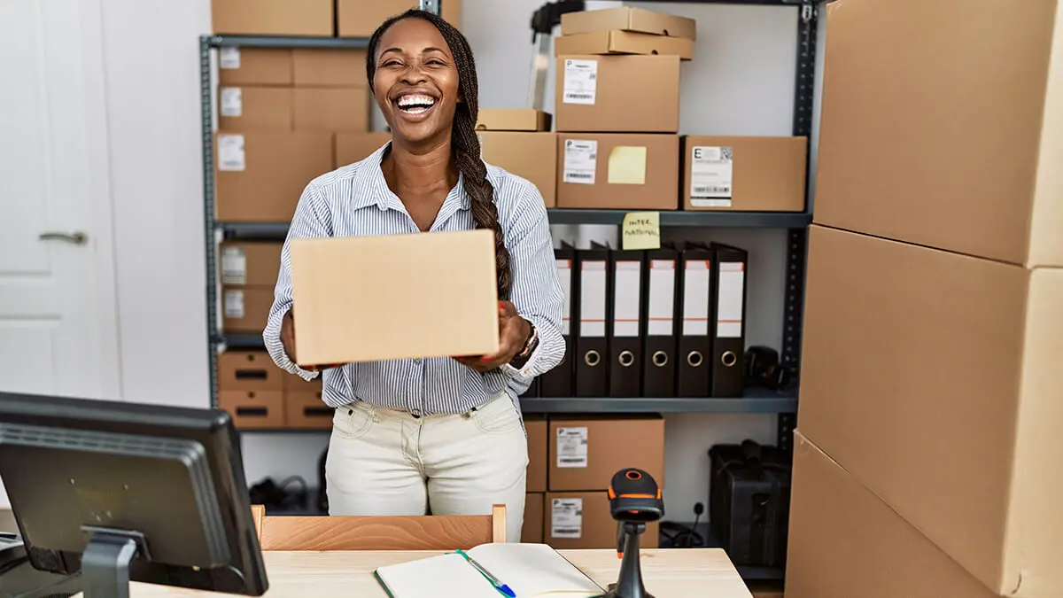 Smiling woman carrying a box