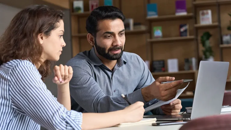 Employees reviewing variable costs on laptop