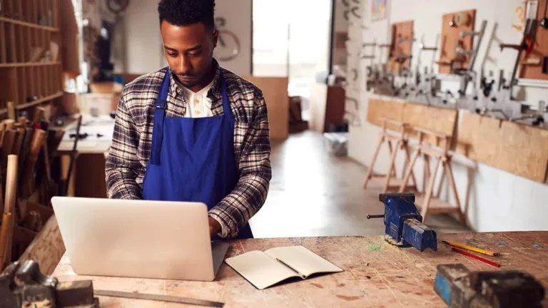 Man in a workshop using laptop