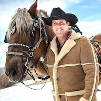 Patriot Software customer Dwight Borges, standing alongside a horse.