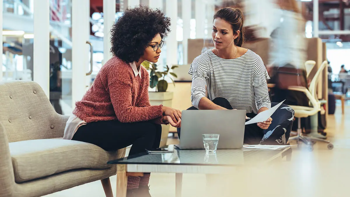 Two women looking at a laptop.