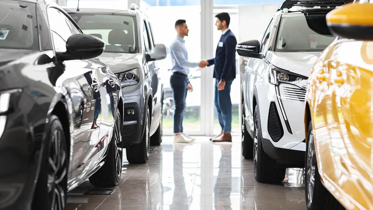 Car dealer shaking buyer's hand