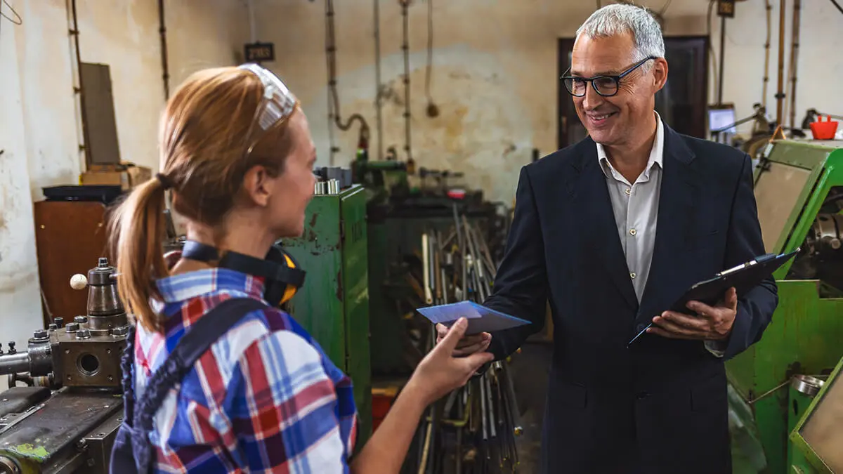 Business owner handing employee a bonus