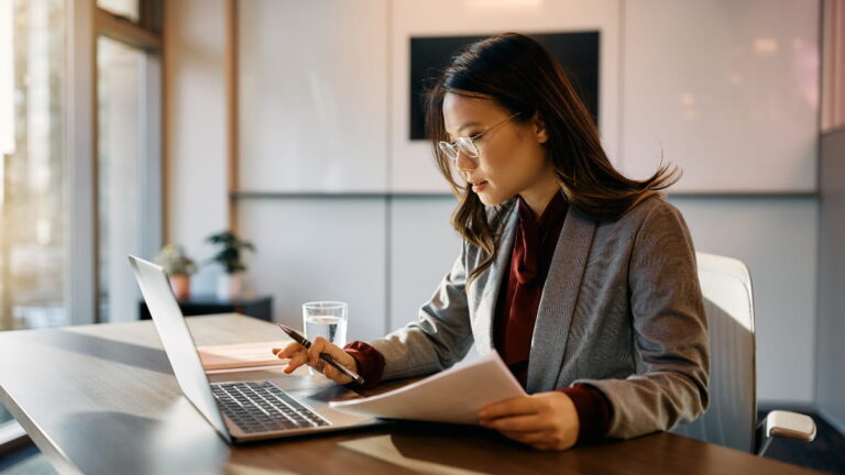 Woman reading through beneficial ownership information documents.