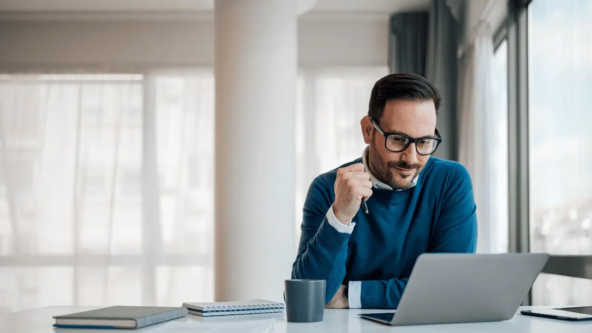 Employer on his laptop to generate pay stubs for employees