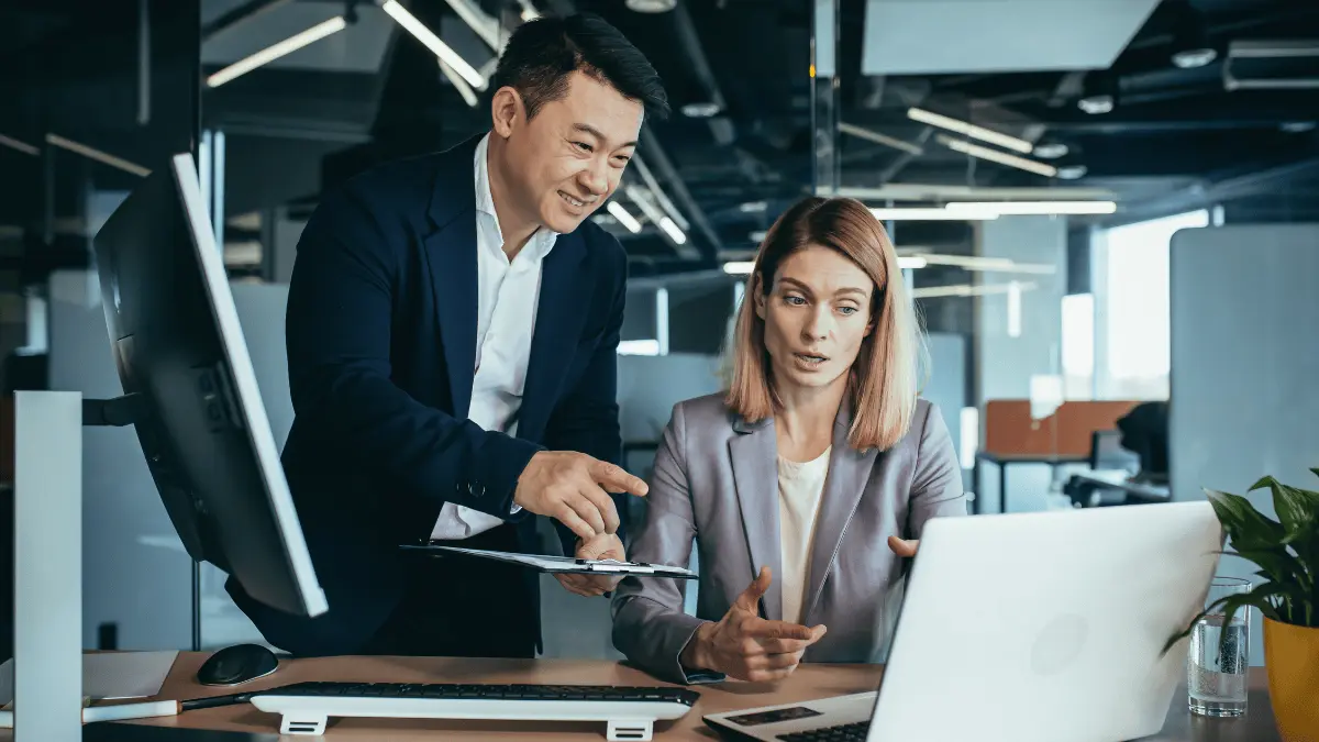 man and woman looking at machine learning in accounting on a laptop