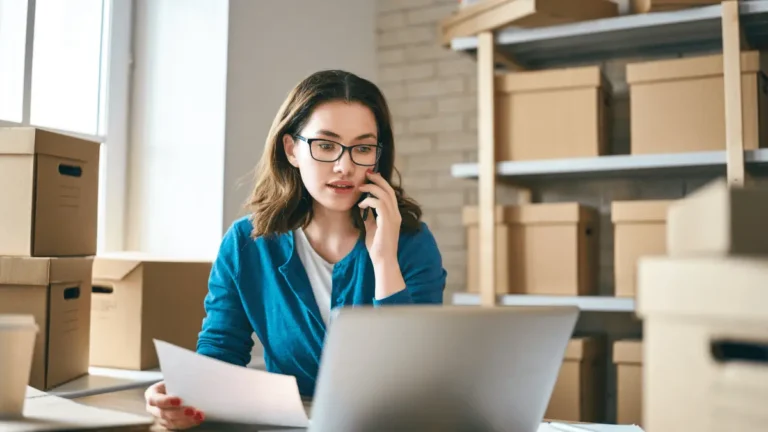 Woman talking to a co-worker over the phone about data entry errors.