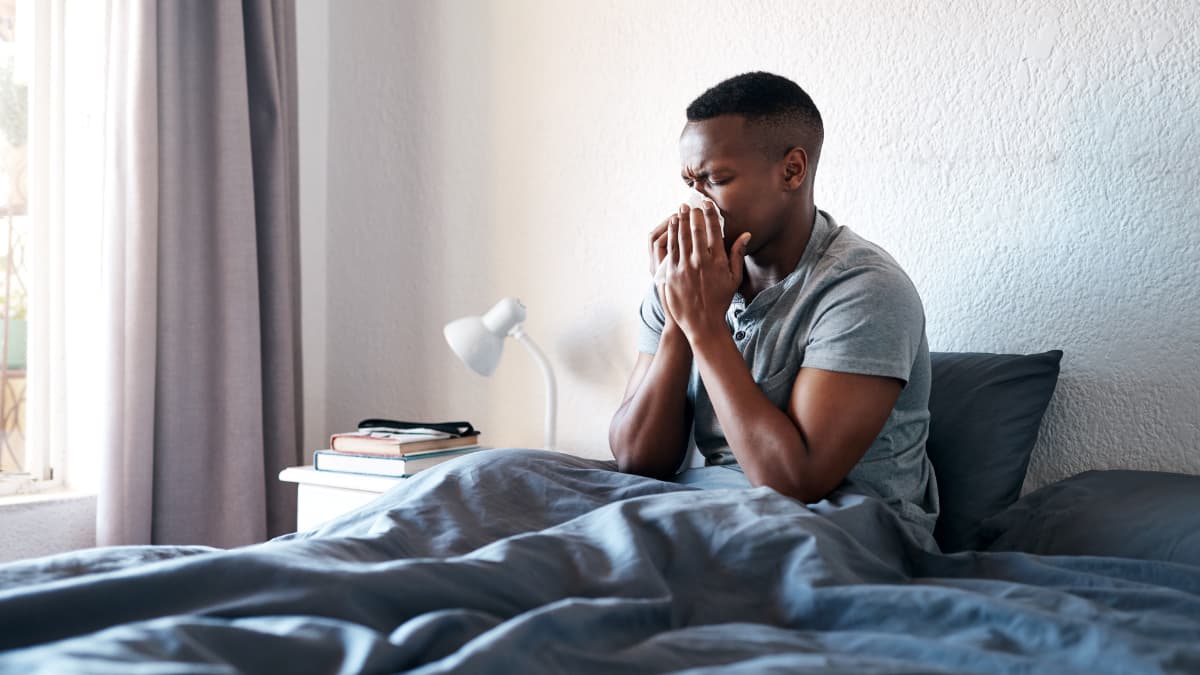 Man in bed taking advantage of Connecticut paid sick leave